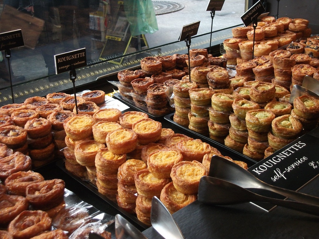 En disk på ett konditori med vackra franska bakverk, så kallade kouignettes.